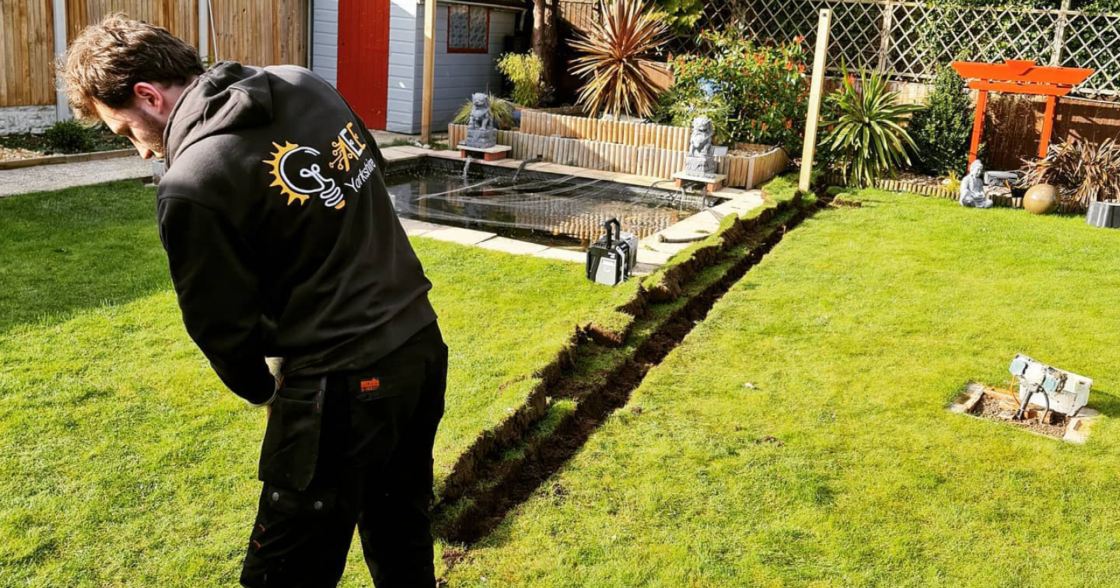 electrician from aee yorkshire digging a trench in the backyard