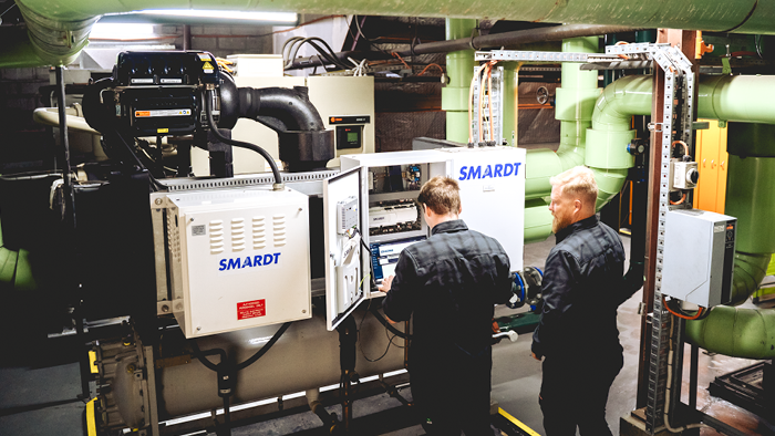 two men standing in-front of cooling system monitor 