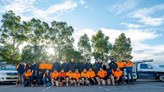 large group of tradies standing outside for a team photo 