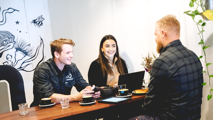 three people sitting at cafe and smiling