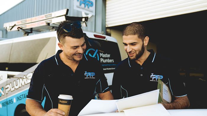 two man looking at papers at smiling