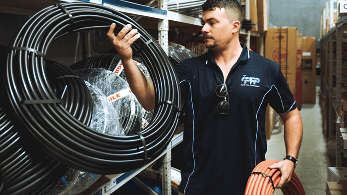 plumber holding two sets of plumbing pipes in hands 