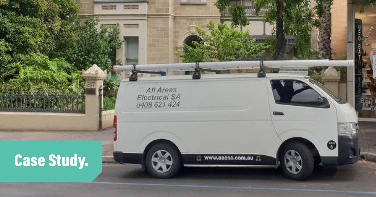 A photo of the all areas electrical white work van parked in front of a heritage brick building