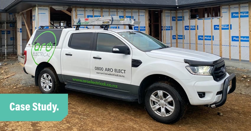 Aro Electrical's white ute parked on the dirt on a building site in front of a partly constructed house. Image overlayed with the words Case Study.