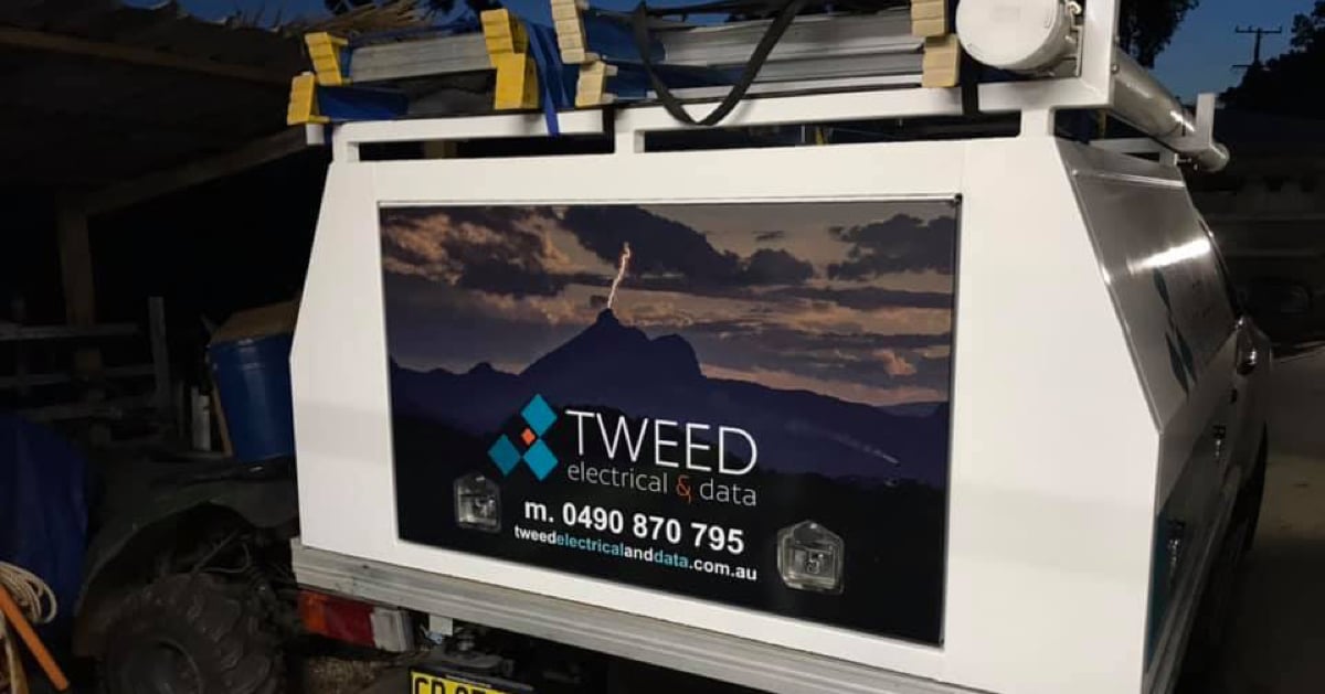 A photo of the back of a Tweed Electrical ute with their logo, phonr number and website address laid over an image of lightening striking a mountain top