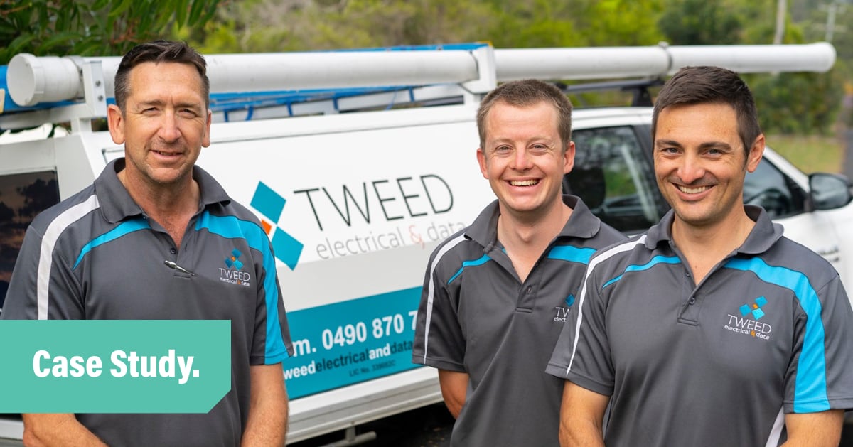 Three men from The Tweed Electrical team standing in front of a company vehicle and smiling