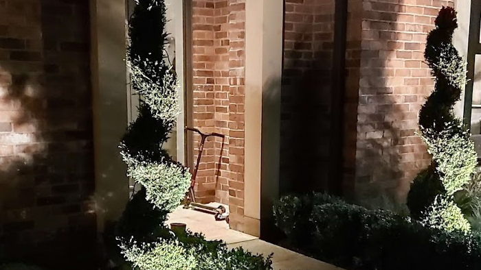 front door of a brick and tile house at night with entrance lit up by down light