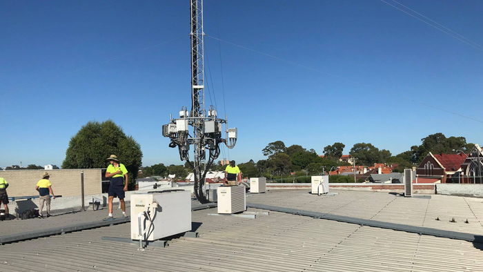 tradies on roof of building working on air condition units