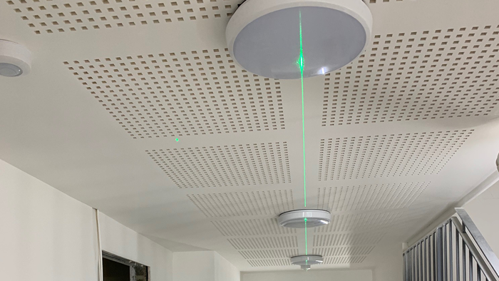 celling with downlight with green laser light running through shot