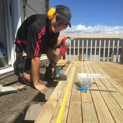 A photo of Andy smiling while building a new deck