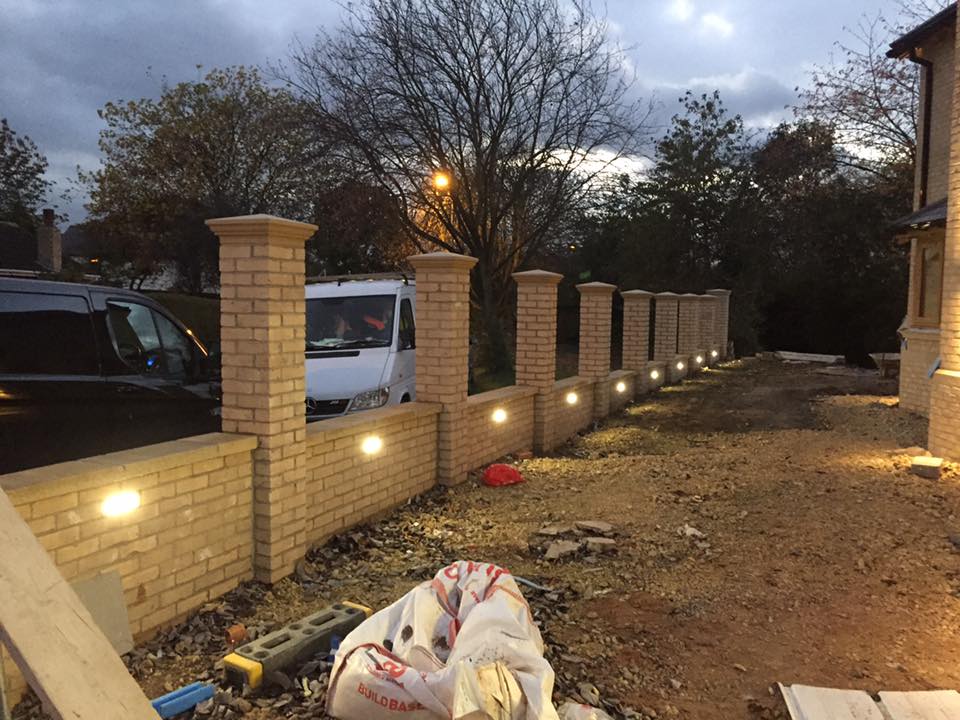 Photo of a complete outdoor light installation by JJ Electrical. Lights have been installed into a new brick fence.