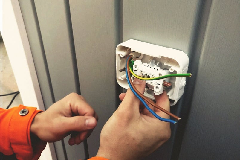 Close up shot of an electrician working on exterior power point