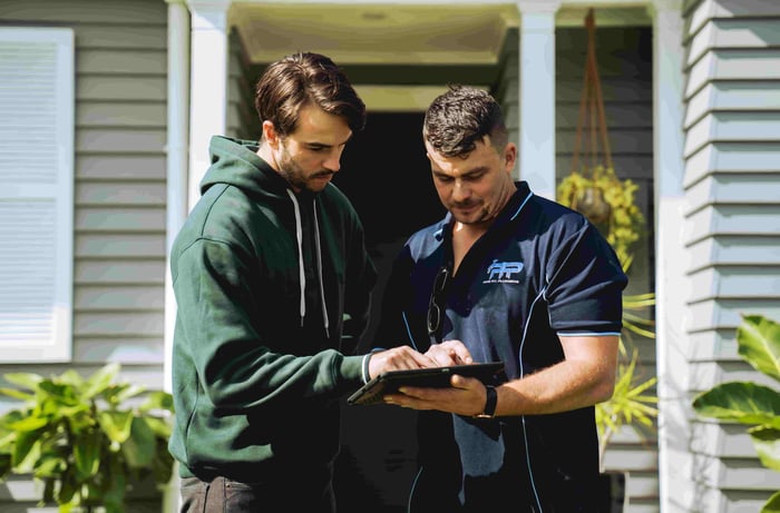 Tradesperson showing tablet to a client