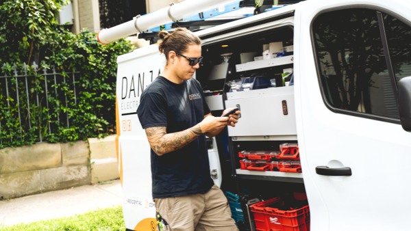 body image_danjac electrical on phone next to white van with milwaukee storage bins