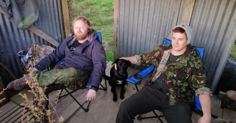 Andrew and friend relax in a shed